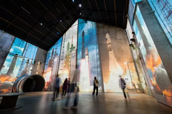 Launch of rockets projected onto large factory wall.